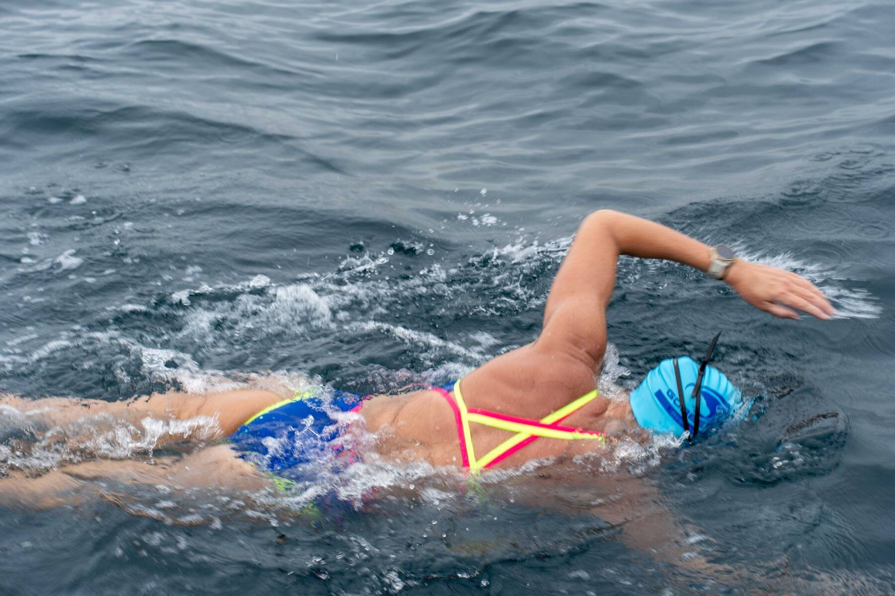 Carina Bruwer swimming through choppy open water with the Durban skyline behind her